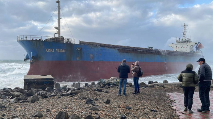 Storm interferes with inspecting the hull of a grounded ship